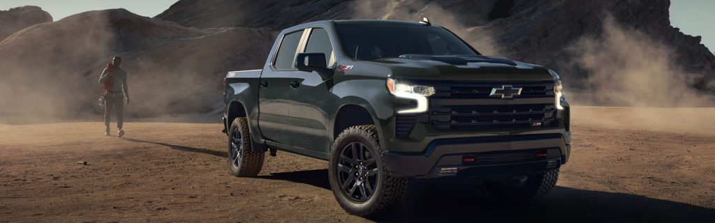 2026 Chevrolet Silverado pickup truck parked on a rugged desert landscape with rocky terrain in the background.